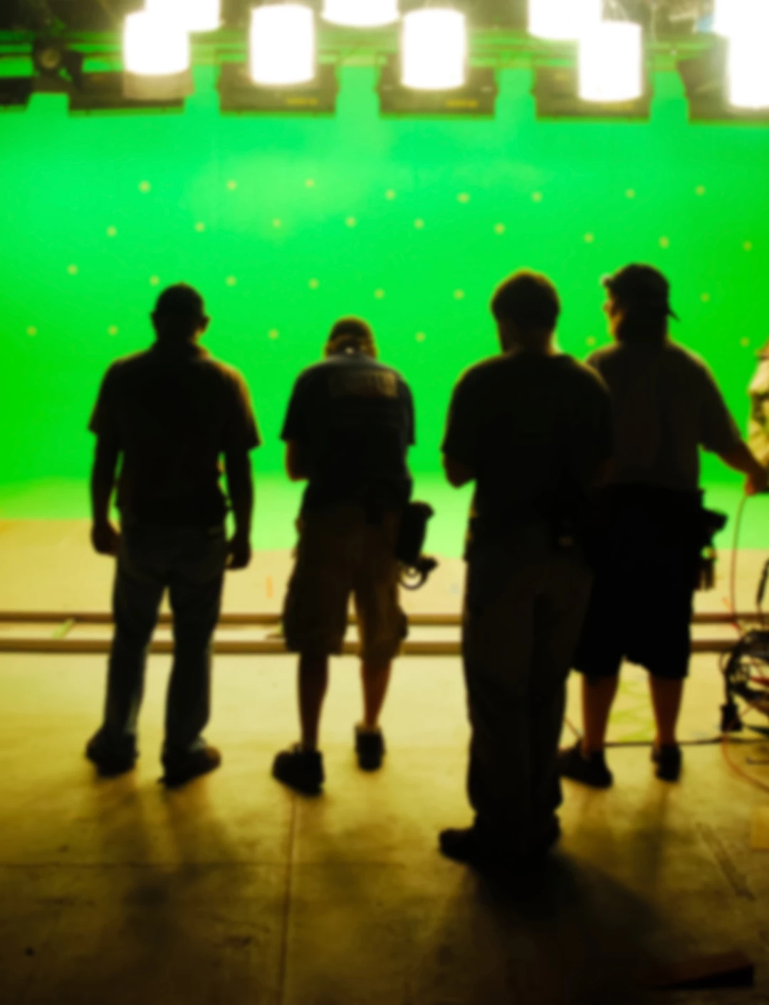 quatro pessoas filmando de frente a tela verde